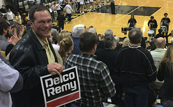 Rob Steele Holding Delco Remy Logo at Basketball Game
